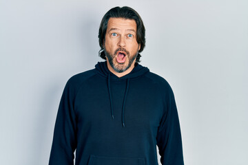 Middle age caucasian man wearing casual sweatshirt afraid and shocked with surprise expression, fear and excited face.