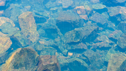 rocks seen from the clear water of the river