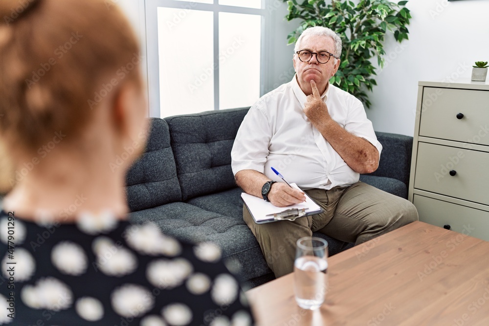 Canvas Prints Senior psychologist man at consultation office thinking concentrated about doubt with finger on chin and looking up wondering