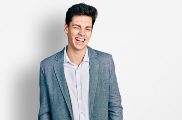 Young hispanic man wearing business clothes winking looking at the camera with sexy expression,...