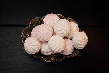 Zephyr served on vintage tray. Beautiful silver plate of sweet zephyrs on black background.