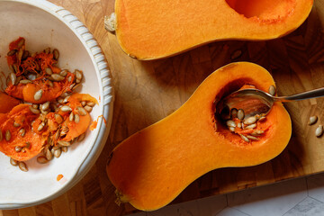 Remove the core of a halved butternut squash. With a spoon, as well as a bowl with the seeds.