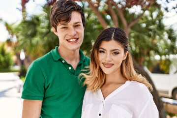 Obraz premium Young caucasian couple smiling happy and hugging standing at the city.