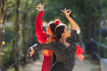 Pair of female flamenco dancers performing a choreography outdoors - obrazy, fototapety, plakaty