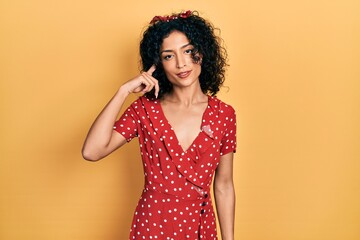 Young latin girl wearing summer dress smiling pointing to head with one finger, great idea or thought, good memory