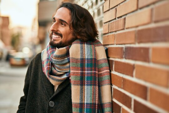 Young hispanic man smiling happy standing at the city.