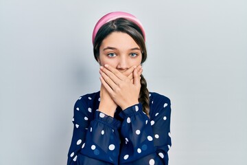 Young brunette girl wearing elegant look shocked covering mouth with hands for mistake. secret concept.