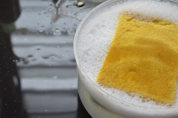 Close up view of kitchen sponge and soapy foam