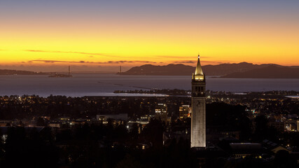 Twilight skies over Sather Tower, (a.k.a. the Campanile) of UC Berkeley via Big C Trail. Berkeley, Alameda County, California, USA. - obrazy, fototapety, plakaty
