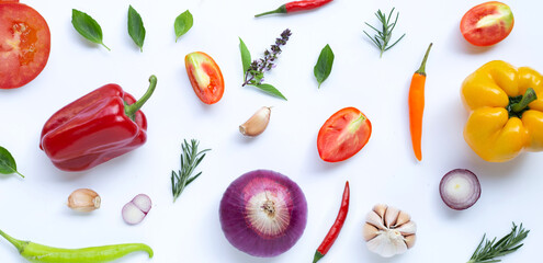 Various fresh vegetables and herbs on white background.