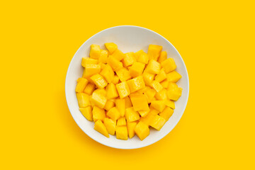 Tropical fruit, Mango cube slices in white plate on yellow background.