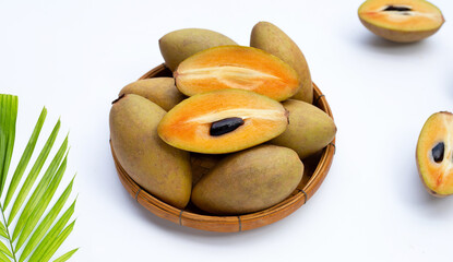 Fresh sapodilla fruit in bamboo basket on white background