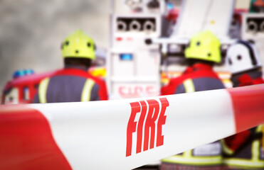 Scene of incident is cordoned off with red and white tape, reading ‘fire’. Out of focus in the...