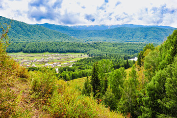 The natural scenery of grassland, forest and mountains under the background of cloudy weather in Xinjiang, China