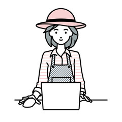 デスクで座ってPCを使っている農家の女性