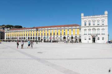 Fototapeta na wymiar Yellow facades with many Roman arches in the old buildings of Praça do Comércio in Lisbon, Portugal. It is one of the largest squares in Europe.