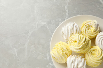 Delicious white and yellow marshmallows on grey marble table, top view. Space for text