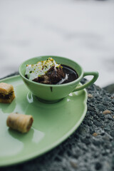 drinking chocolate in matching green cup and plate with assorted baklava desserts