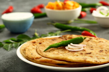 Indian vegetarian meal- healthy vegan diet - aloo paratha served with spicy potato curry and raita,.