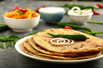 `Indian street foods- aloo paratha served with potato curry and fresh raita.