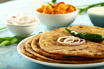 Homemade delicious Indian vegan diet meal- aloo paratha with potato curry and fresh raita.