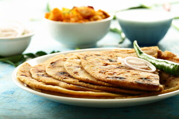 Aloo paratha - poato masala stuffed Indian flat bread served with fresh raita.