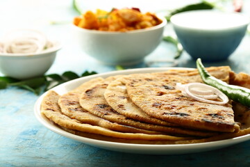 Punjabi dhaba style meal- aloo paratah with fresh raita and potato curry.