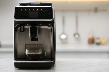 Modern electric espresso machine making coffee on white marble countertop in kitchen