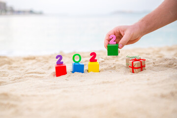 hand puts the number 2 2022 on the sea
