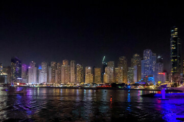 Fototapeta na wymiar Panoramic view at night of Business Bay district with reflection in sea, UAE. Aerial sky at highest buildings in central Dubai, United Arab Emirates. High quality photo