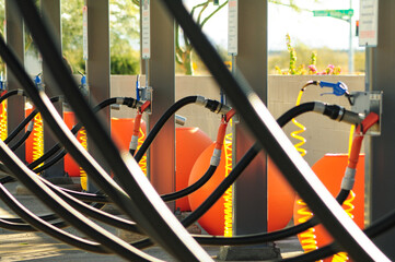 A web of vacuum hoses and other cleaning equipment at a self-service car wash business - obrazy, fototapety, plakaty