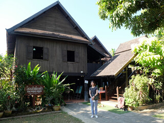 Thai woman in front of the Noble House, Nan province, Thailand.