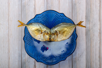 Two smoked sea fish close-up in a plate
