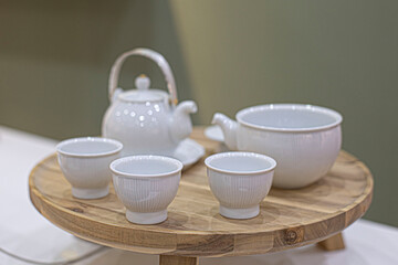 White porcelain tea set on wooden table.