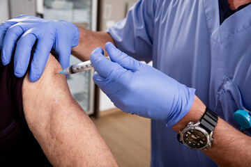 Covid-19 Vaccine Injection Close Up by a Male Nurse with Gloves using a Syringe Needle with Elderly...