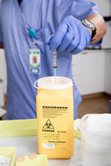 Safe Disposal of Syringe Needle in Sharps Collector after Administering a Covid-19 Vaccine. Close...