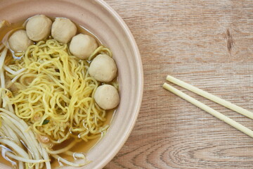 boiled Chinese yellow egg noodles with pork meatball and bean sprout in soup on bowl
