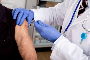 Covid-19 Vaccine Injection Close Up by a Male Doctor with Gloves using a Syringe Needle with...