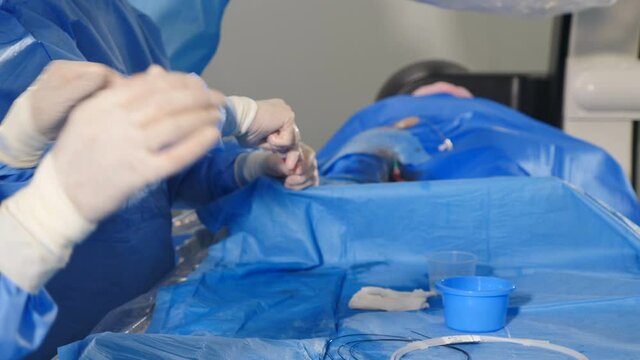 Vascular surgery. Hands of radiologist performing endovascular operation with angiography machine. Doctor using contrast liquid for uterine fibroid embolization. Cardio-vascular examination. getting