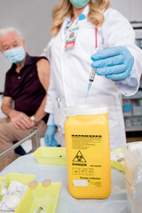 Safe Disposal of Syringe Needle in Sharps Collector after Administering a Covid-19 Vaccine. Close...