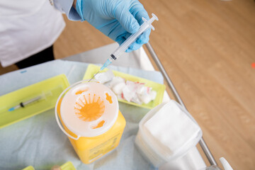 Safe Disposal of Syringe Needle in Sharps Collector after Administering a Covid-19 Vaccine. Close...