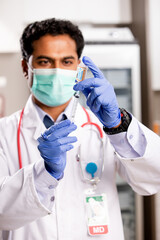 A Young Indian Male Medical Doctor Extracting a Covid-19 Vaccine Injection with a Syringe Needle...