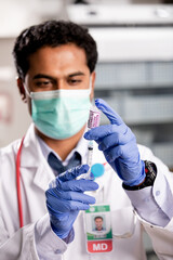 A Young Indian Male Medical Doctor Extracting a Covid-19 Vaccine Injection with a Syringe Needle...