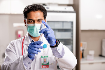 A Young Indian Male Medical Doctor Extracting a Covid-19 Vaccine Injection with a Syringe Needle...