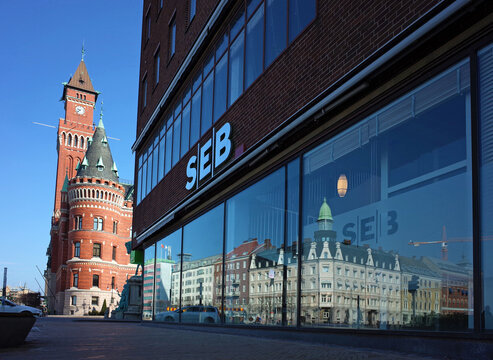 Helsingborg, Sweden - 14 April, 2018: Windows of SEB bank building view from Jarnvagsgatan street with clock tower of Town Hall. Helsingborg is port city located in southern Sweden on shore of Oresund