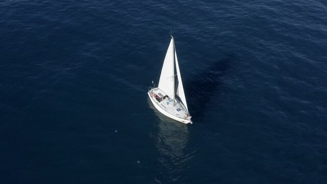 Small Sail boat in calm sea water, Aerial view. 