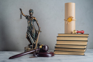 Lady Justice, Judge's gavel, books, parchment scroll with seal and stamp on an old wooden table