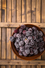 blackberry in a bowl on a wooden background