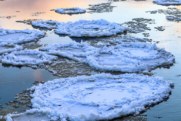 Ice floes float along a river. Ice drift. Winter in Europe