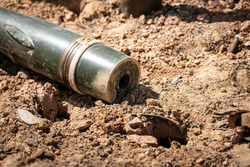 An explosive bomb is remained on battlefield ground. Close-up and selective focus.